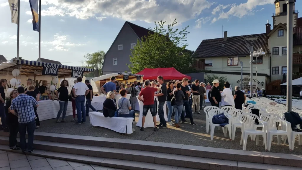 Foto von Marktplatz mit Bierbänken und Menschen beim Open-Air-Kino Event in Weilheim