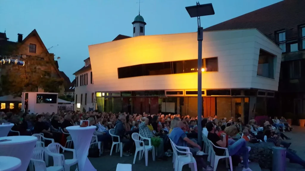Foto von Marktplatz in Abendstimmung mit Menschen beim Open-Air-Kino Event in Weilheim