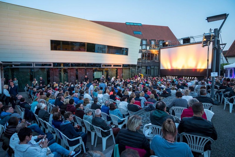 Foto vom Open Air Kino in Weilheim an der Teck, Marktplatz, viele Menschen auf Plastikstühlen, große Leinwand